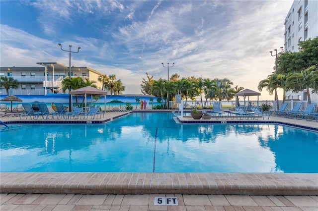 community pool with a patio and fence