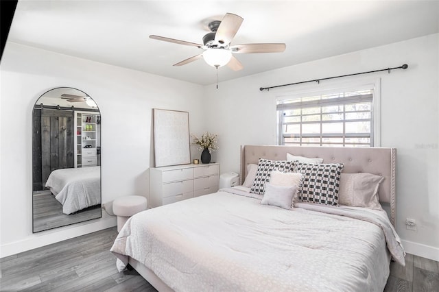 bedroom with wood finished floors, baseboards, and ceiling fan