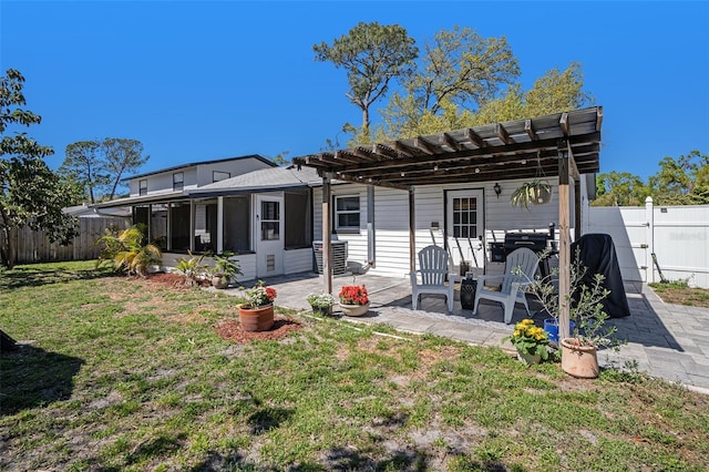 back of house featuring a patio, a fenced backyard, a pergola, and a lawn