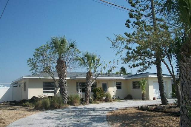 single story home featuring stucco siding and driveway