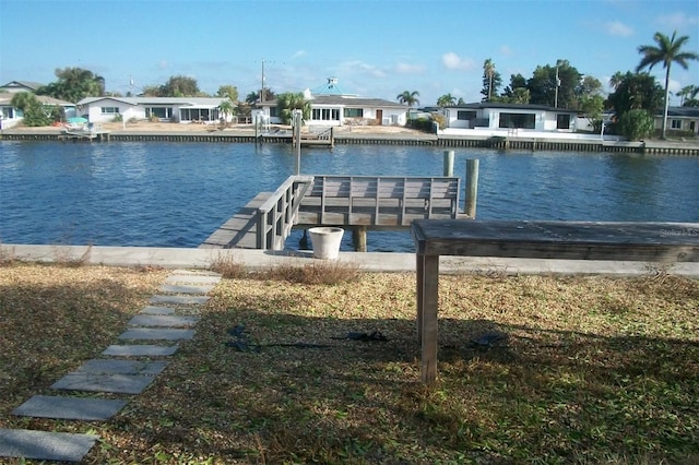 view of dock with a residential view and a water view