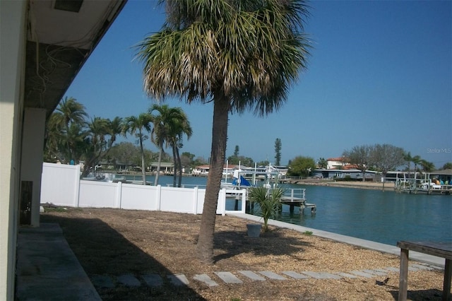 property view of water with fence and a boat dock