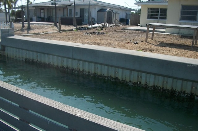 exterior space featuring a storage unit, fence, an outdoor structure, and a water view