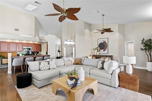 living area featuring light wood-type flooring, visible vents, and a ceiling fan