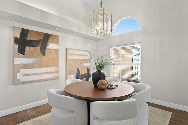 dining room featuring wood finished floors, baseboards, a wealth of natural light, and a chandelier