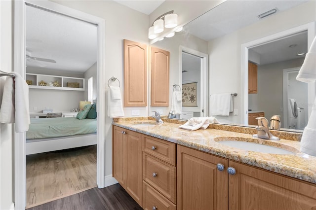 full bathroom with double vanity, visible vents, wood finished floors, and a sink