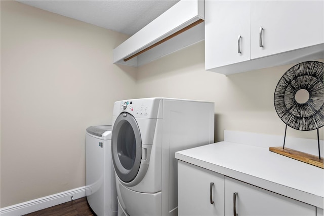 laundry room with cabinet space, independent washer and dryer, dark wood-style flooring, and baseboards