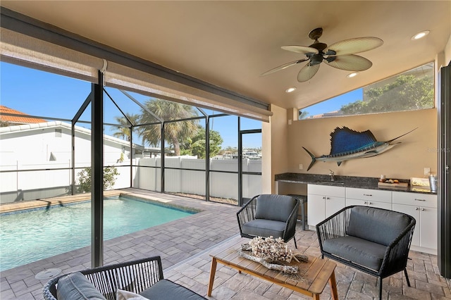 view of pool with a patio, a fenced in pool, an outdoor kitchen, a sink, and a lanai