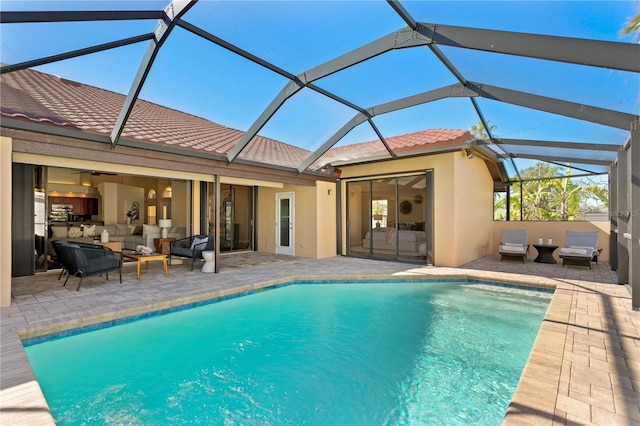 outdoor pool with glass enclosure, outdoor lounge area, and a patio area