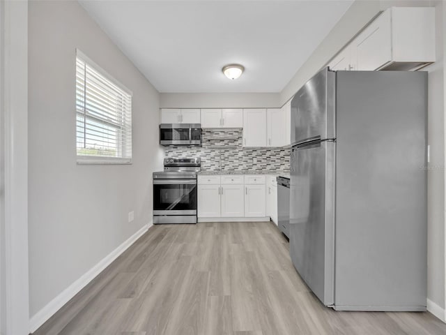 kitchen featuring tasteful backsplash, light wood-style flooring, white cabinetry, and stainless steel appliances