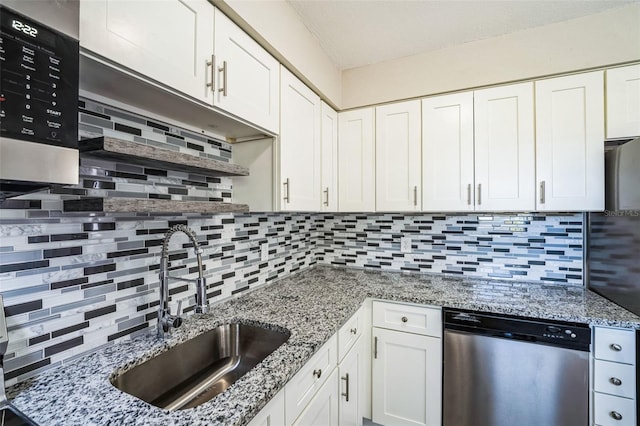 kitchen featuring backsplash, white cabinetry, stainless steel appliances, and a sink