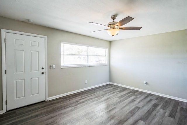 interior space with dark wood-type flooring, a ceiling fan, and baseboards