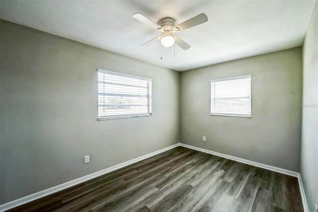 unfurnished room with baseboards, a ceiling fan, a healthy amount of sunlight, and dark wood-style flooring