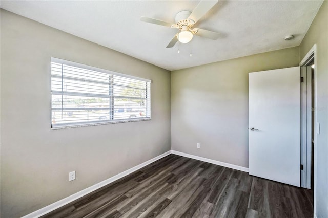 unfurnished bedroom with a ceiling fan, baseboards, and dark wood-style flooring