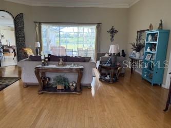 living area with crown molding and wood finished floors