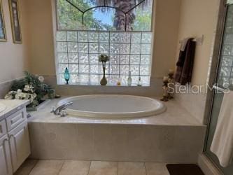 bathroom with tile patterned floors, a stall shower, vanity, and a bath