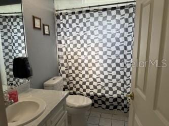 bathroom featuring tile patterned floors, toilet, a shower with shower curtain, and vanity