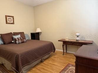 bedroom featuring wood finished floors and baseboards