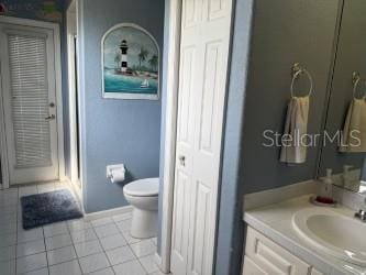 full bath with tile patterned flooring, toilet, and vanity