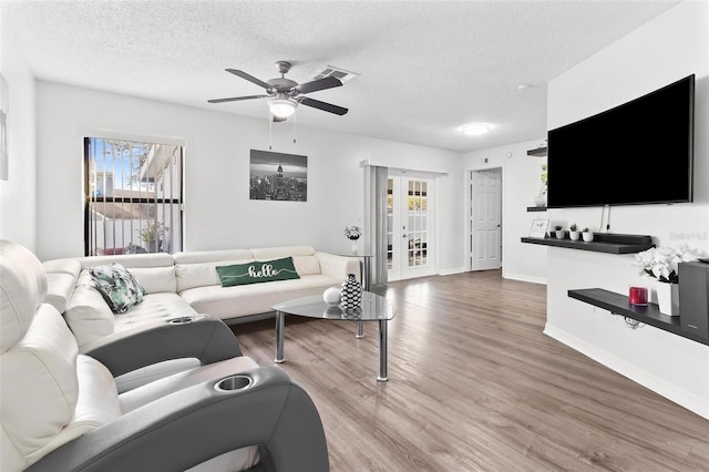 living room with french doors, a textured ceiling, ceiling fan, and wood finished floors