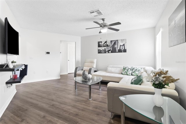 living room featuring visible vents, a textured ceiling, ceiling fan, and wood finished floors