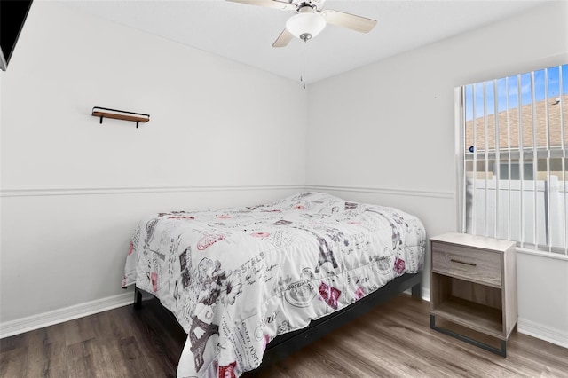 bedroom featuring a ceiling fan, baseboards, and wood finished floors