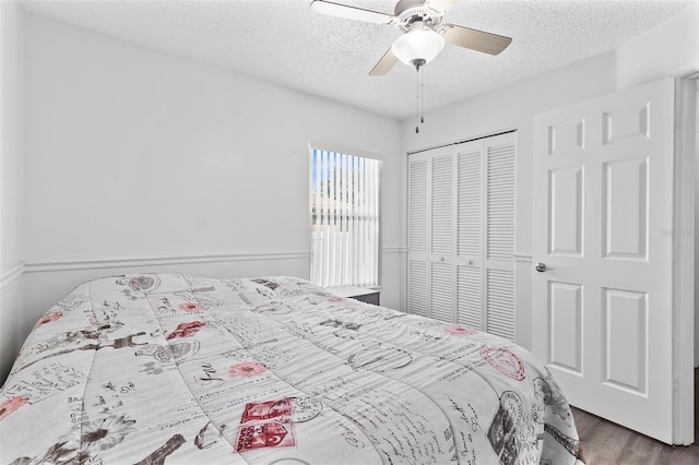 bedroom featuring a ceiling fan, wood finished floors, a closet, and a textured ceiling