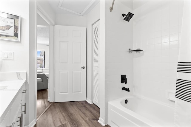 ensuite bathroom featuring ensuite bathroom, wood finished floors, baseboards, bathtub / shower combination, and vanity