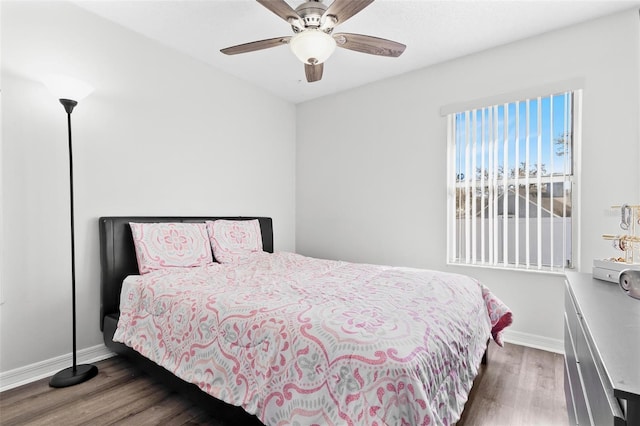 bedroom with ceiling fan, baseboards, and wood finished floors