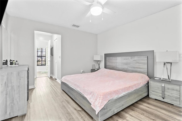 bedroom with visible vents, a ceiling fan, baseboards, and wood finished floors