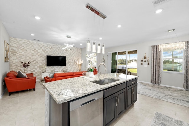 kitchen featuring dishwasher, an accent wall, a wealth of natural light, and a sink