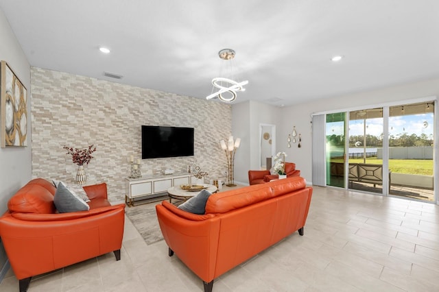 living room with a chandelier, visible vents, recessed lighting, and an accent wall