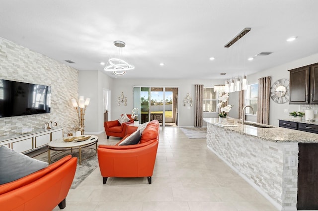 living room featuring light tile patterned floors, visible vents, recessed lighting, and an inviting chandelier