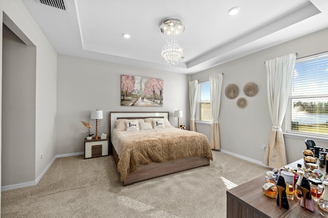 bedroom featuring a notable chandelier, carpet flooring, a raised ceiling, and baseboards