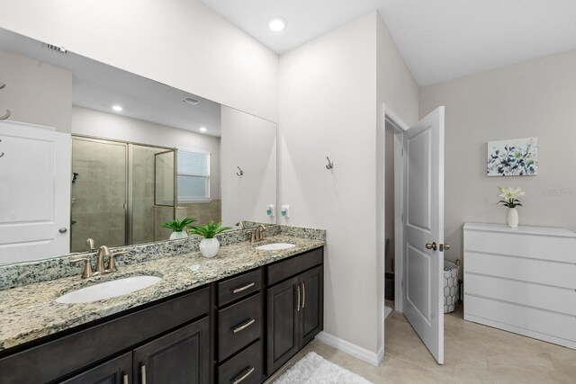 bathroom with double vanity, tile patterned flooring, a shower stall, and a sink