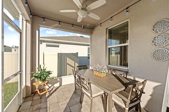 sunroom featuring rail lighting and a ceiling fan