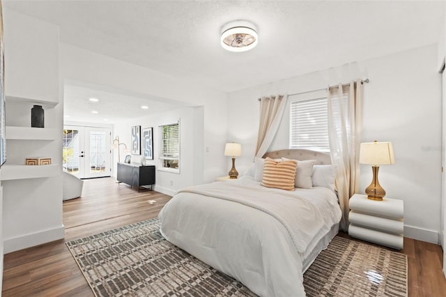 bedroom featuring french doors, baseboards, and wood finished floors