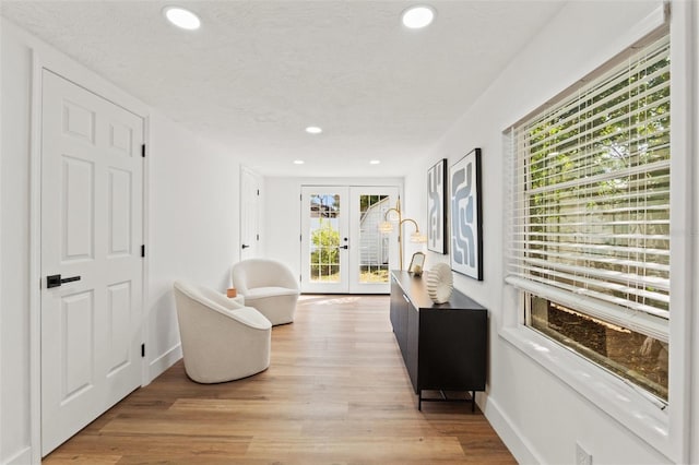 sitting room featuring light wood finished floors, recessed lighting, french doors, and baseboards