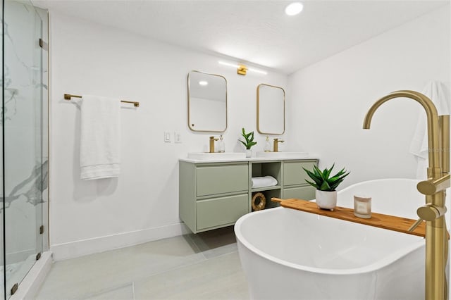 bathroom with baseboards, double vanity, a stall shower, a soaking tub, and a sink