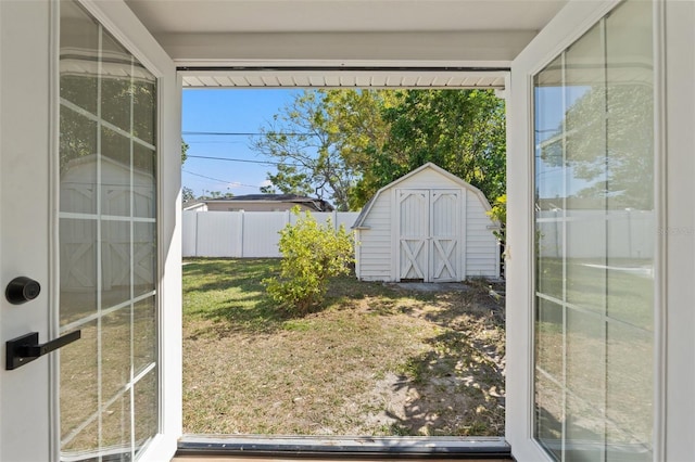 view of yard with an outdoor structure, a storage unit, and fence