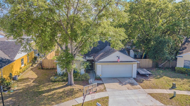 view of property hidden behind natural elements with stucco siding, an attached garage, concrete driveway, and fence