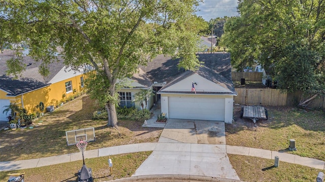 view of front of home featuring an attached garage, concrete driveway, and fence