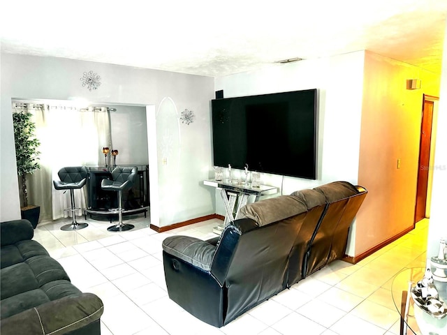 living area featuring tile patterned flooring, visible vents, and baseboards