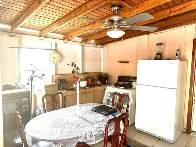 interior space featuring tile patterned flooring, beamed ceiling, wooden ceiling, freestanding refrigerator, and a ceiling fan