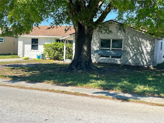 view of front of home with a front yard and stucco siding