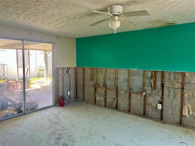 interior space with a textured ceiling and a ceiling fan