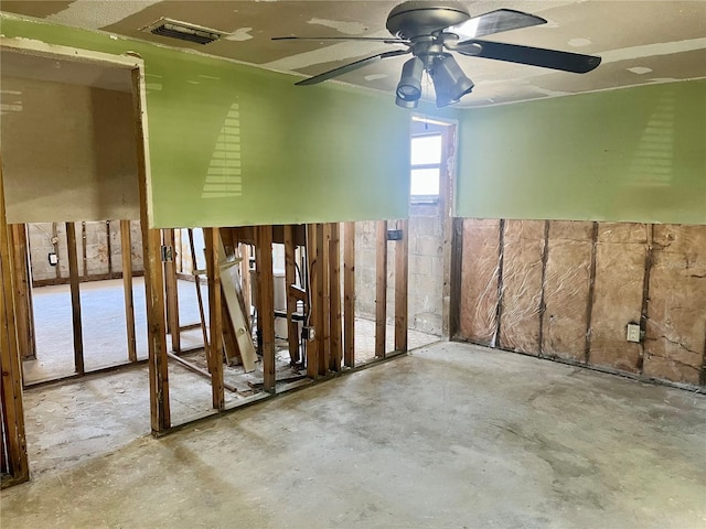 interior space featuring unfinished concrete flooring and a ceiling fan