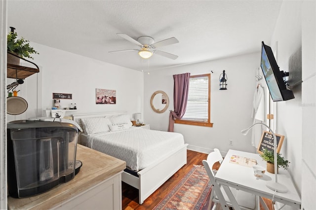 bedroom featuring baseboards, a ceiling fan, dark wood-style flooring, and a textured ceiling