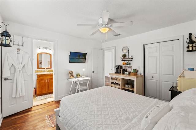 bedroom featuring visible vents, a sink, wood finished floors, a closet, and ceiling fan