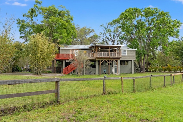 back of property featuring stairs, a deck, and a lawn